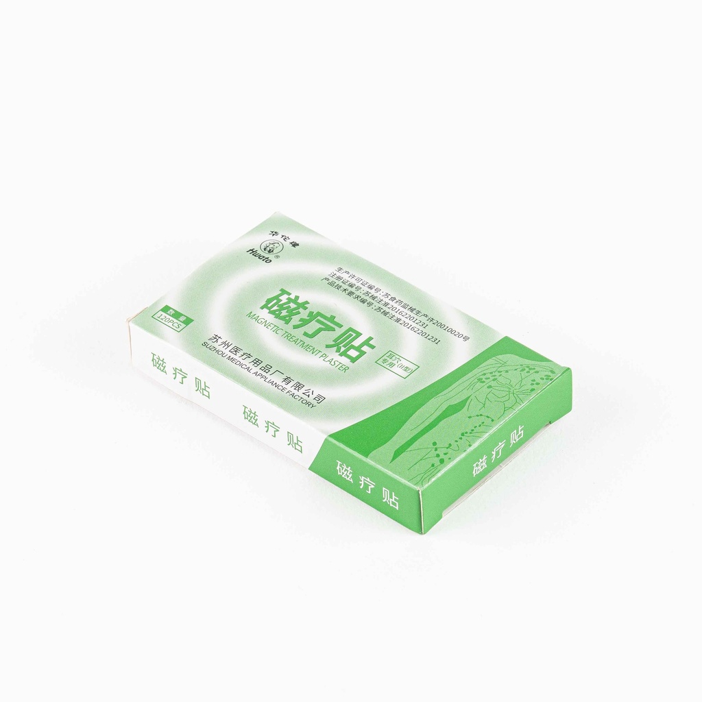 Caja verde y blanca de microimanes para auriculoterapia marca Hwato. El empaque muestra texto en chino e inglés con el nombre “Magnetic Treatment Plaster”. Fondo blanco.